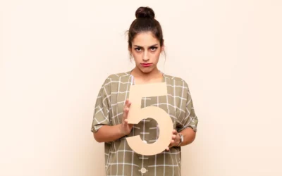Person holding a large number five, wearing a checkered shirt.