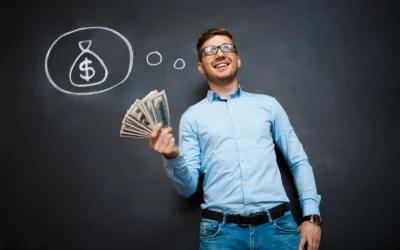 Smiling man holds cash beside a chalkboard drawing of a money bag.
