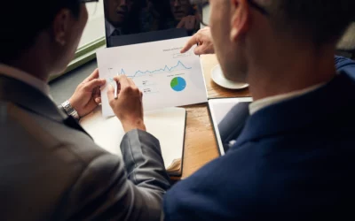 Two people discussing a financial chart with graphs and a pie chart.