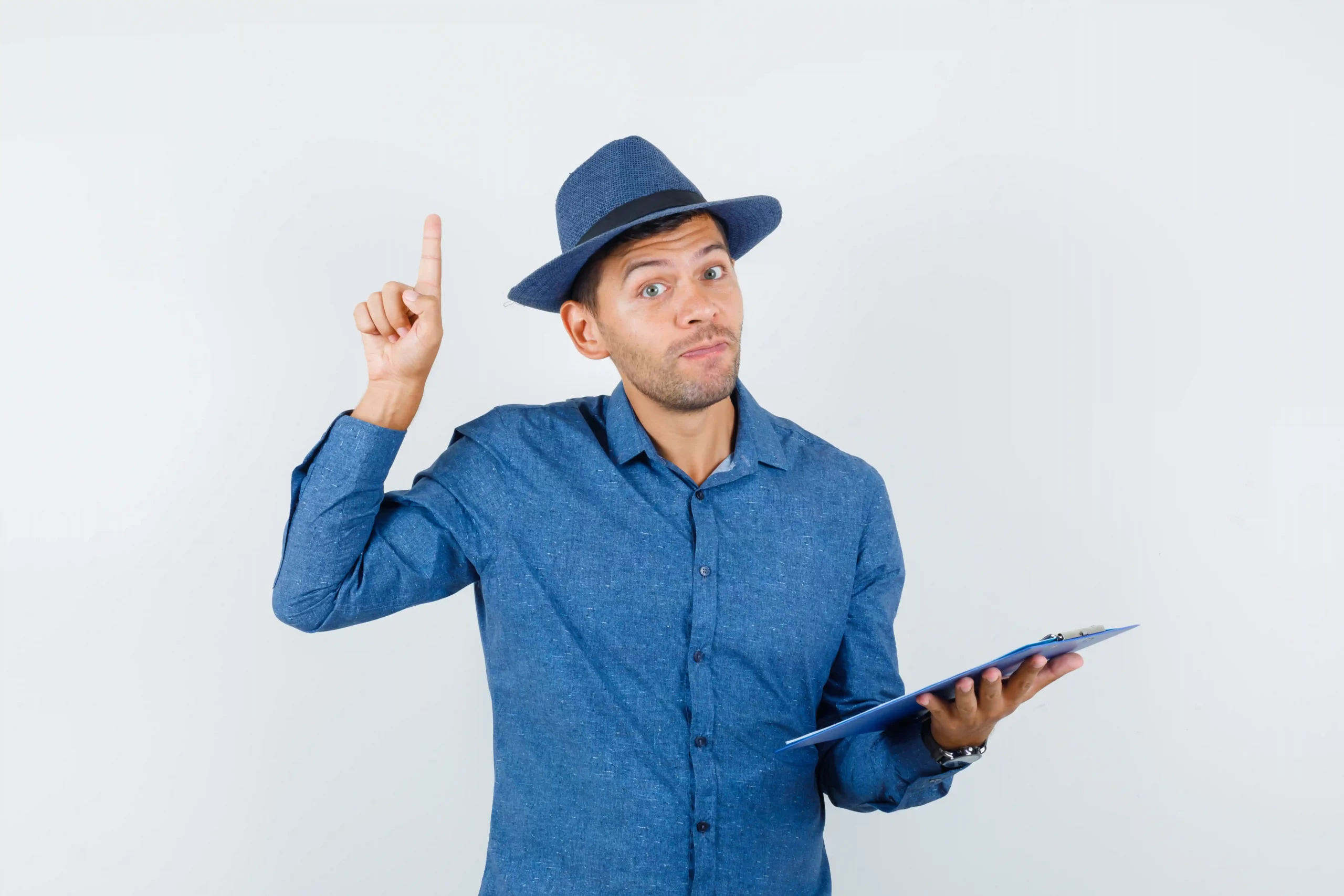 Person in blue shirt and hat holding clipboard, raising one finger.