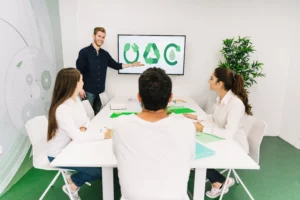 People in a meeting discussing recycling symbols on a screen.