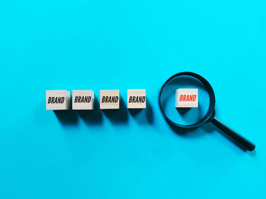 Magnifying glass highlighting one of five "Brand" blocks on blue background.