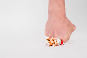 A hand crushing a pack of cigarettes.